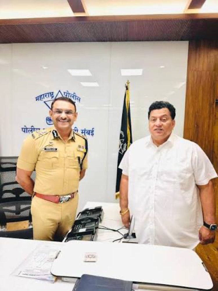 Milind Bharambe in Maharashtra Police uniform with a visitor at the Navi Mumbai Commissioner of Police headquarters, in front of signage reading Commissioner of Police, Navi Mumbai.