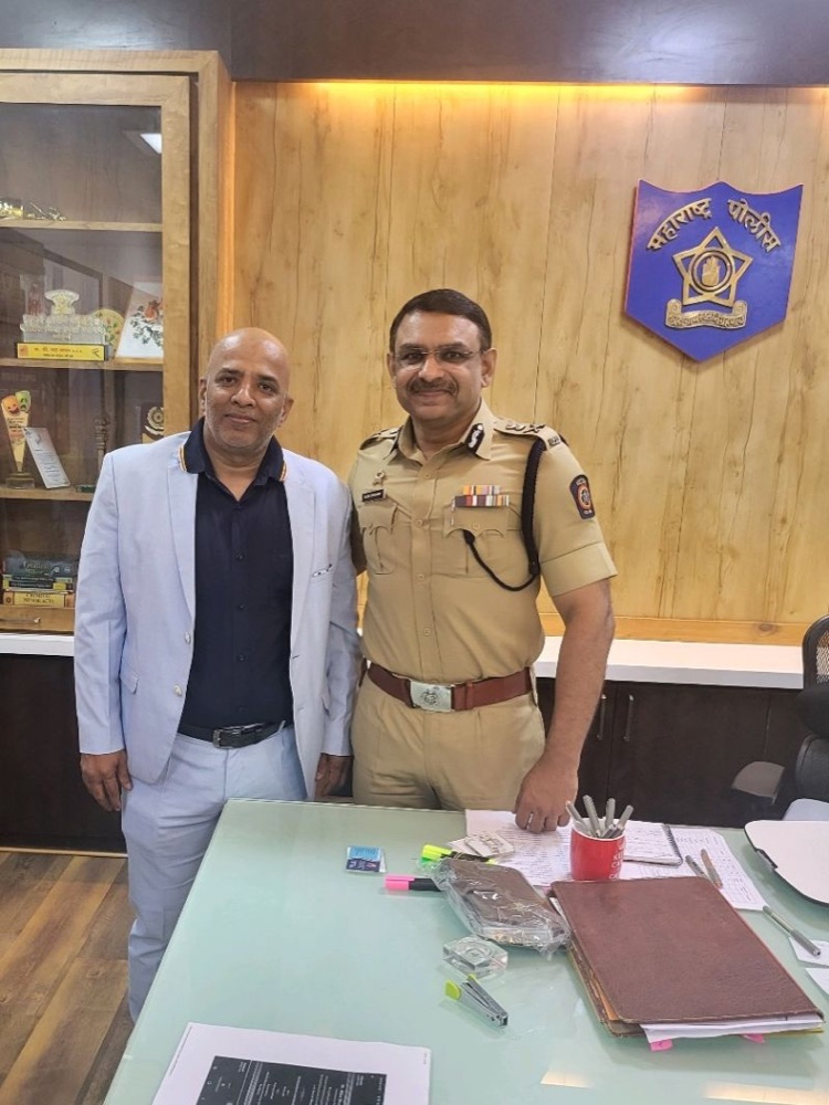 Milind Bharambe in Maharashtra Police uniform standing with Mr Digant Sharma in the commissioner's office, beside the Maharashtra Police emblem.