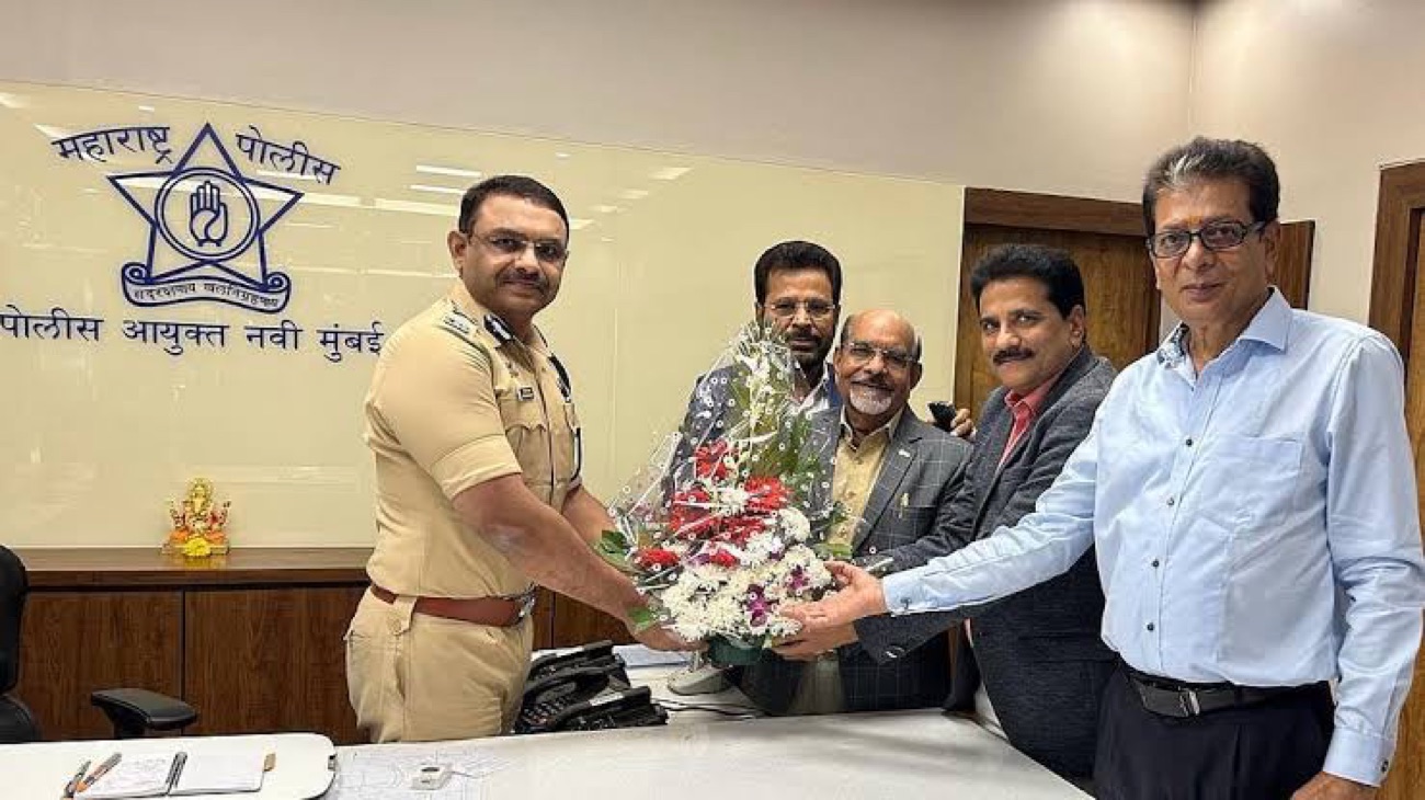 Milind Bharambe in uniform receiving a bouquet from a delegation of four visitors at the Navi Mumbai Commissioner of Police office.