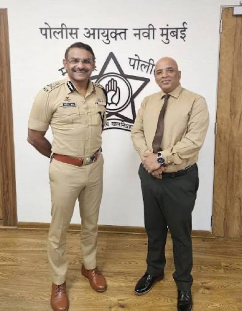 Milind Bharambe in Maharashtra Police uniform standing with a visitor at the Commissioner of Police office, Navi Mumbai, beneath the Maharashtra Police emblem.